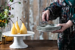 a woman holding a plate with pears on it