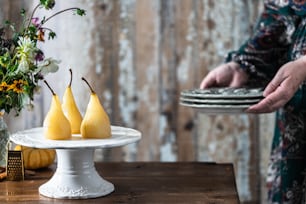 a person holding a plate with three pears on it