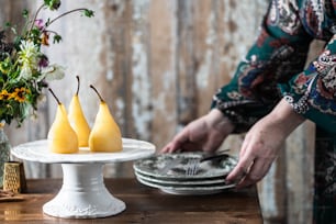 a woman is cutting pears on a cake plate