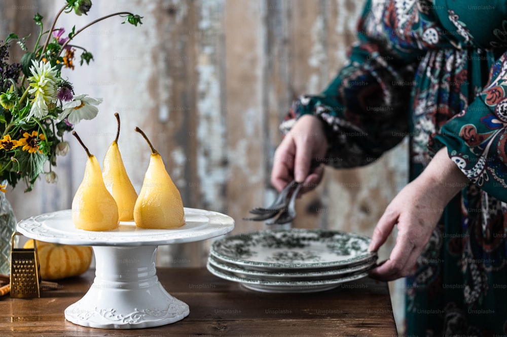 a woman is cutting pears on a plate