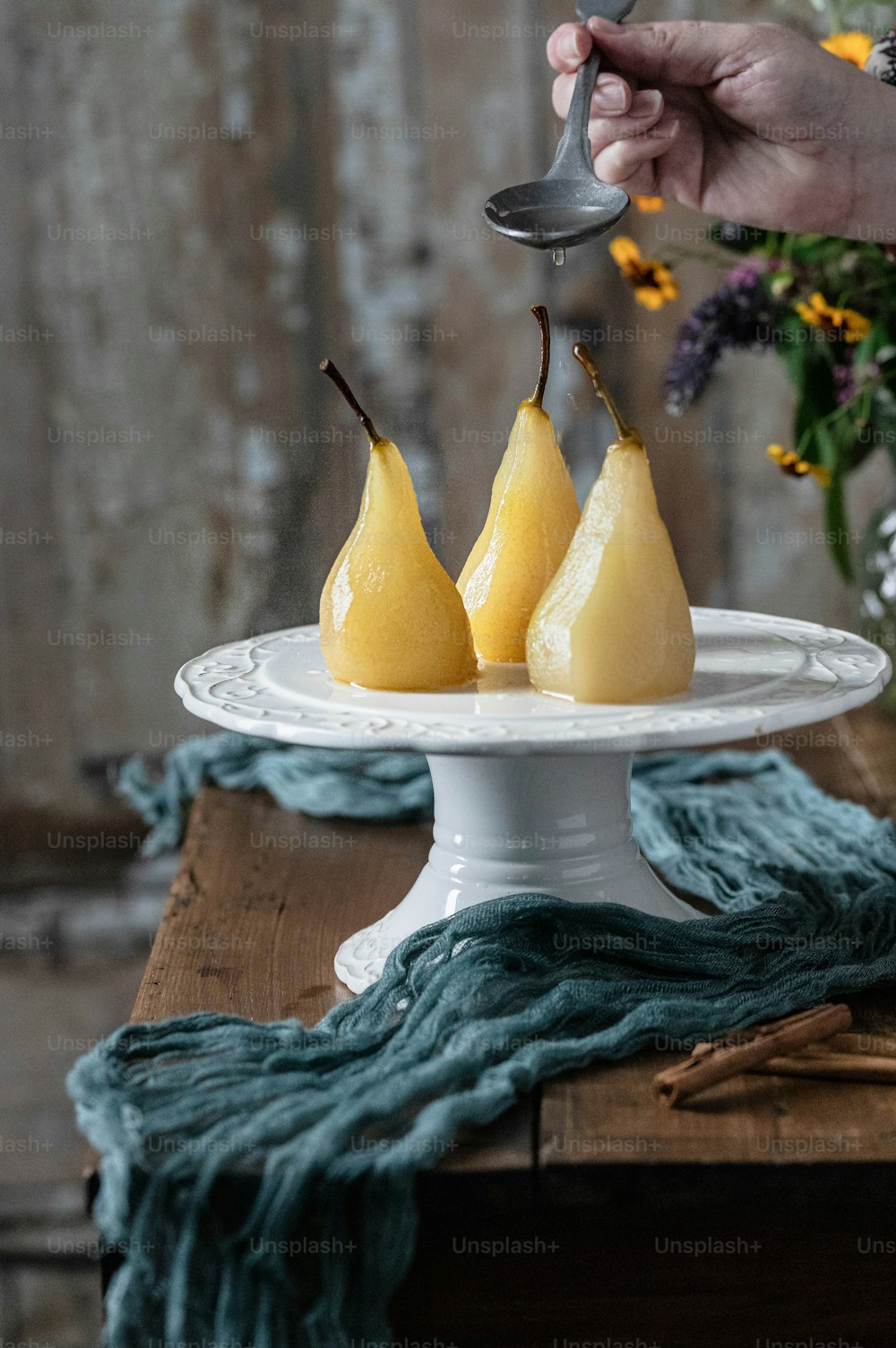 a white plate topped with three pears on top of a table