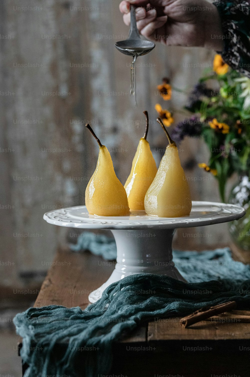 テーブルの上に3つの梨をト��ッピングした白い皿