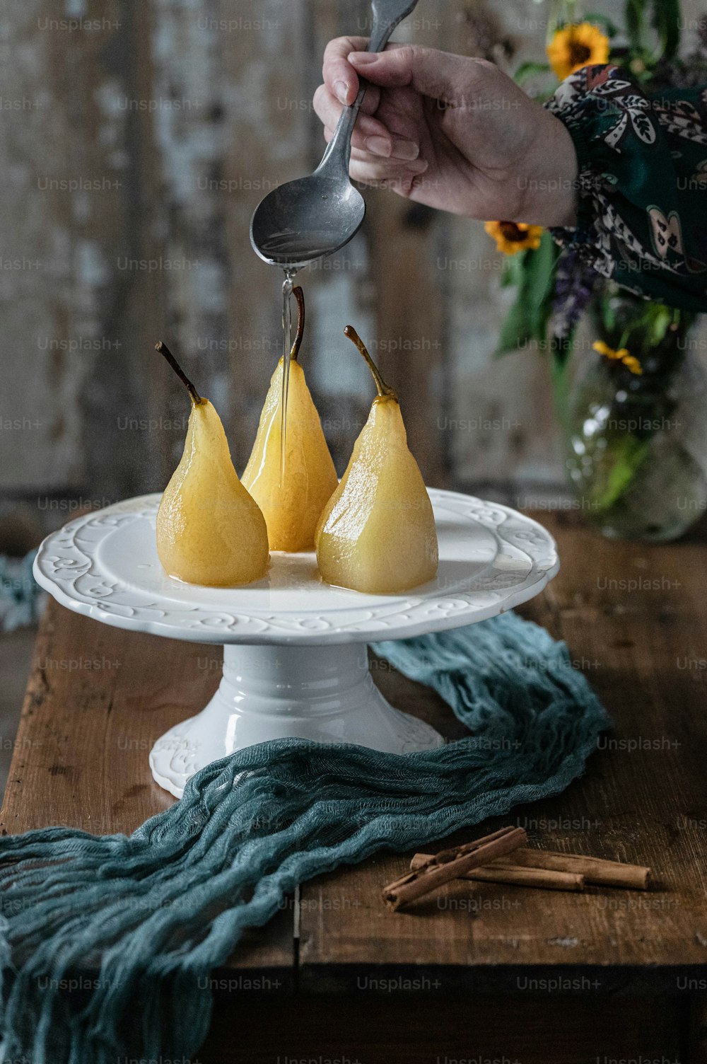a white plate topped with three pears on top of a wooden table