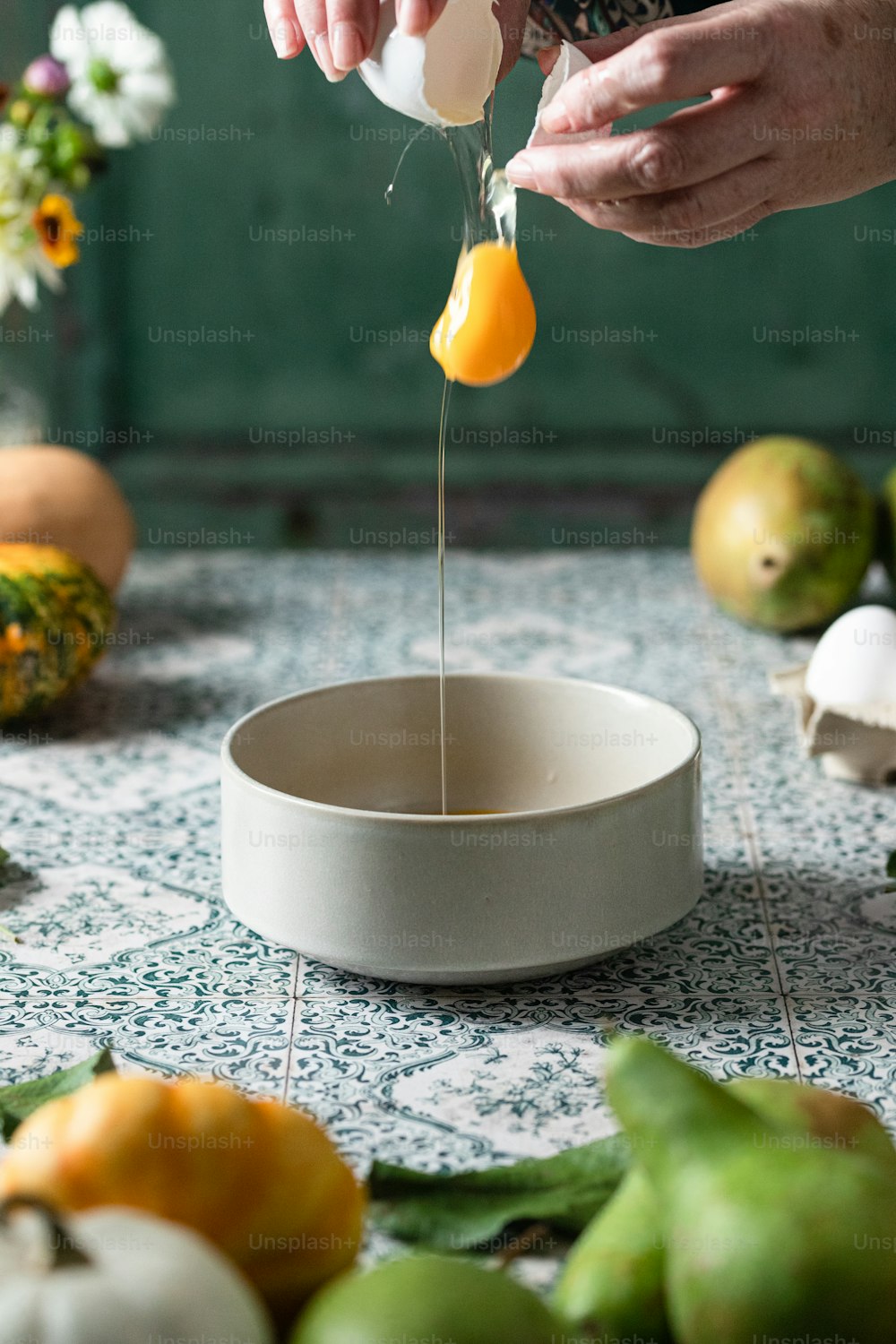 a person is squeezing an egg into a bowl