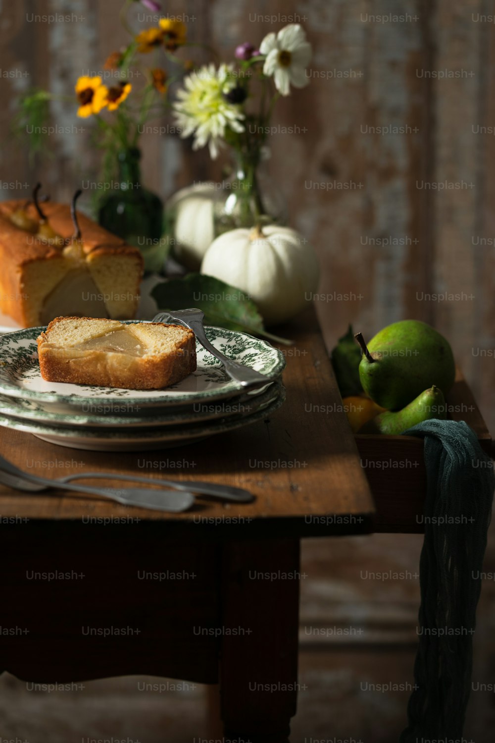 a table topped with a loaf of bread next to a plate of fruit