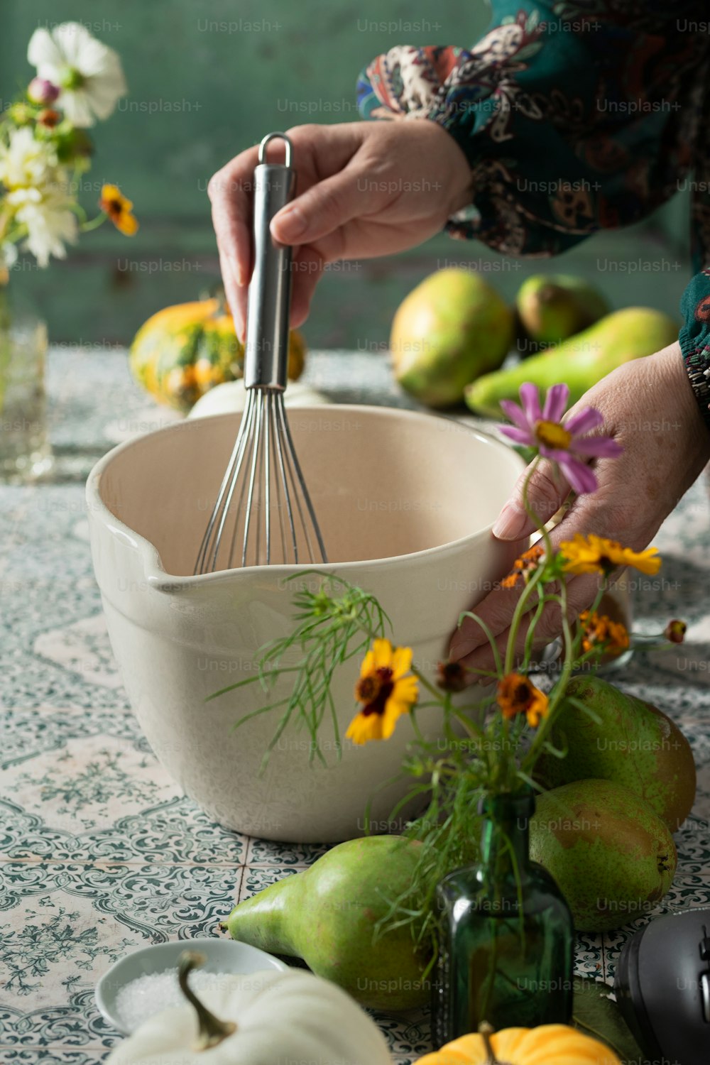 a person whisking a whisk over a bowl of fruit