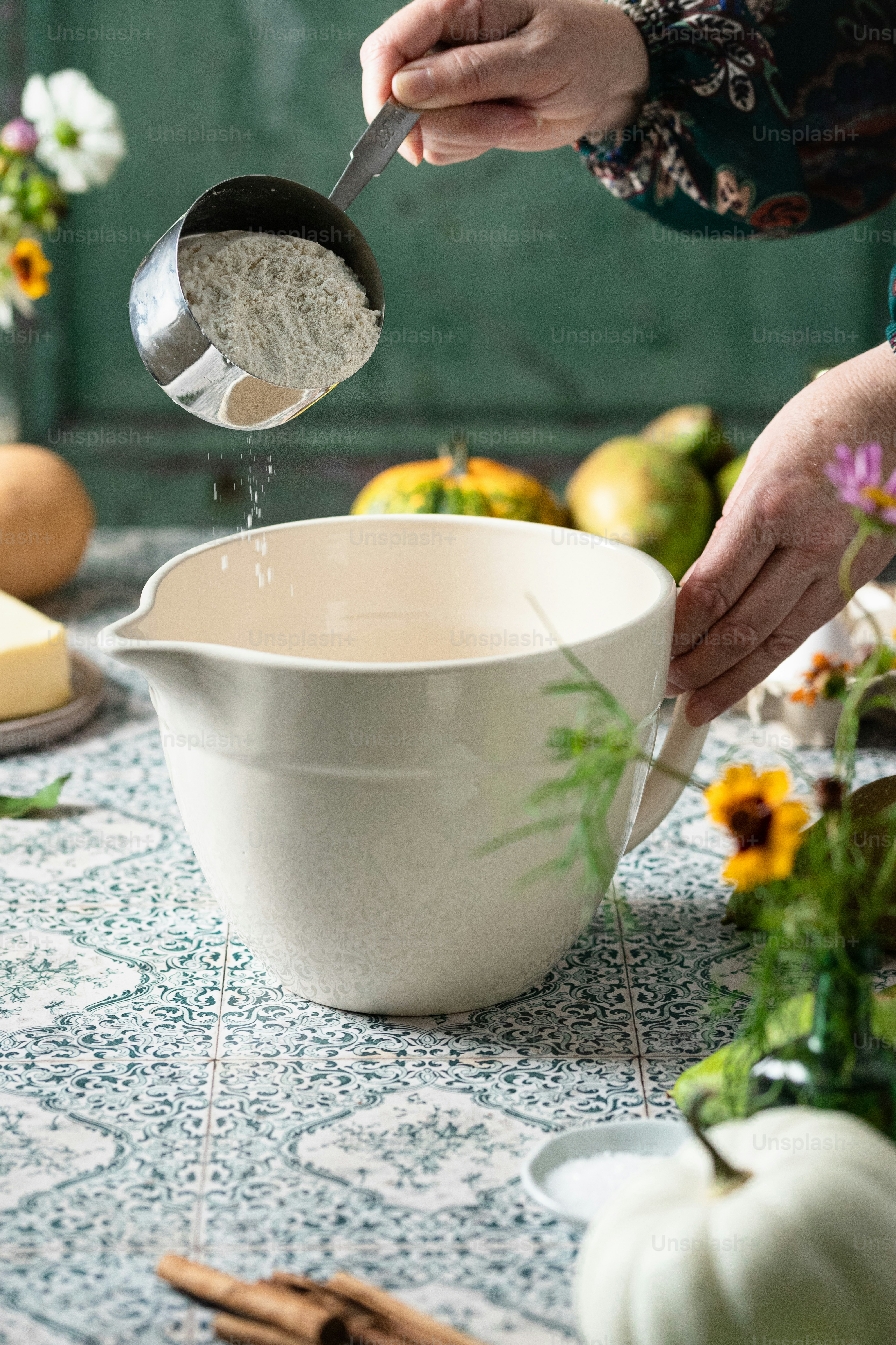 une personne versant du sucre dans un bol blanc