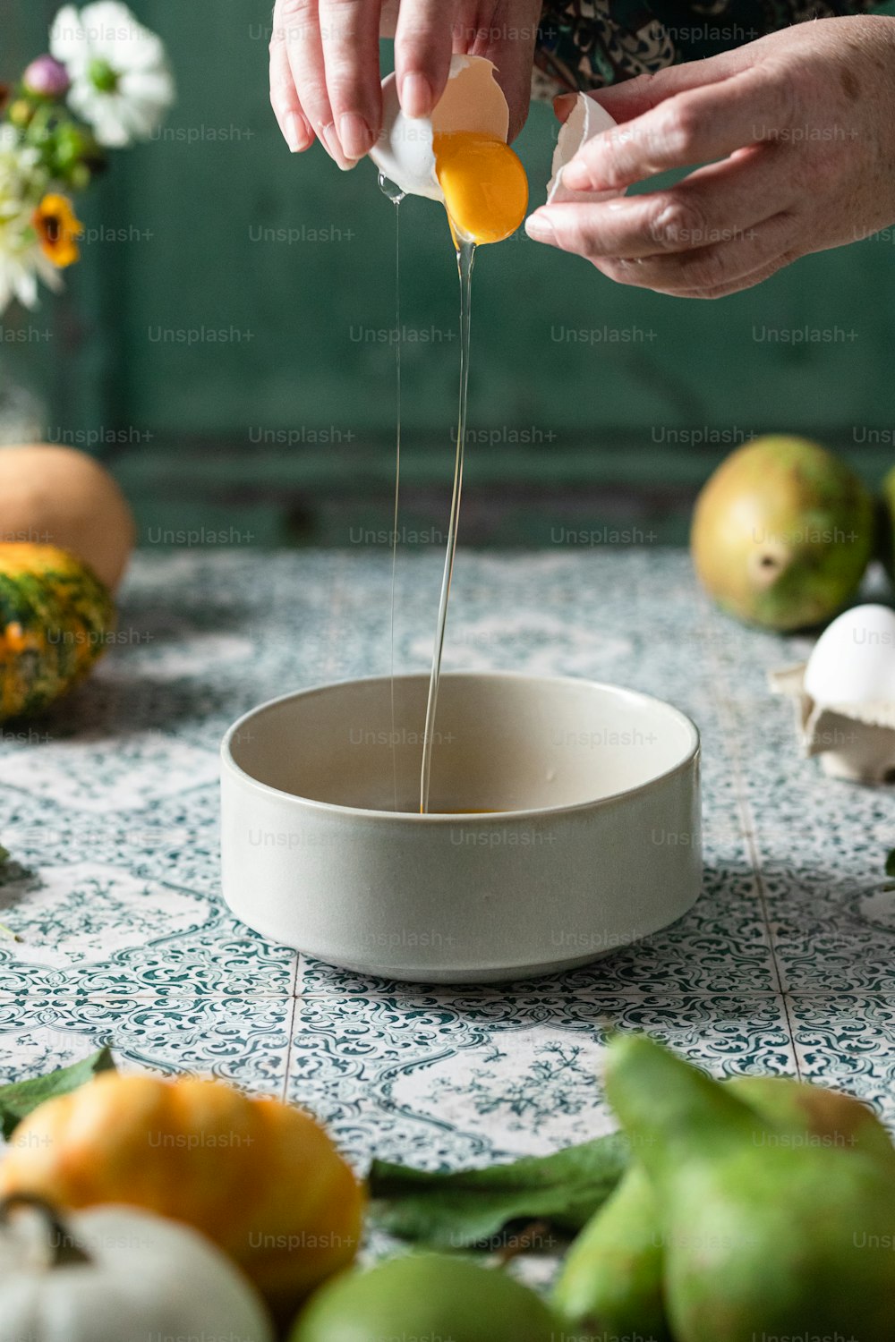 a person pouring eggs into a bowl on a table