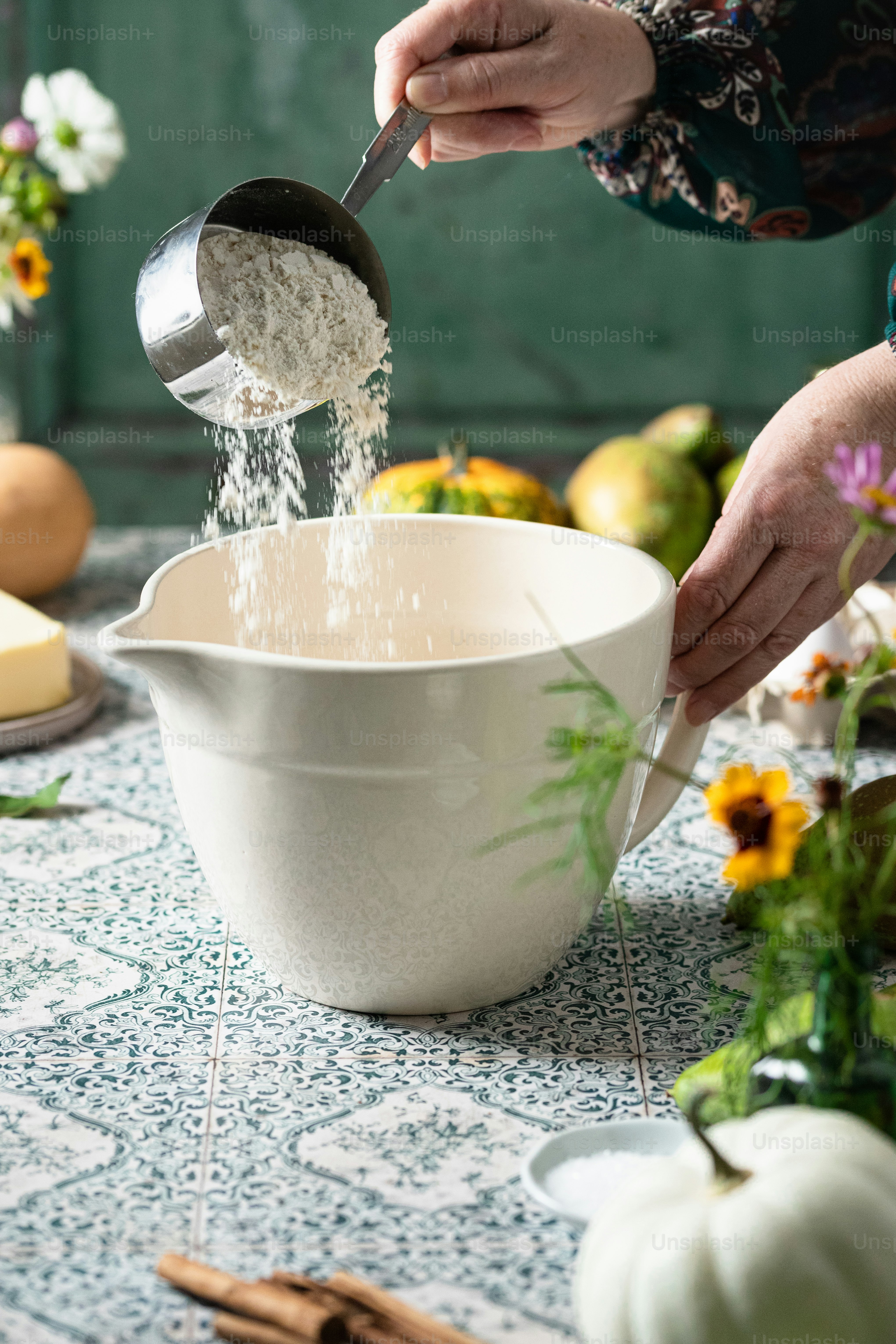 eine person, die zucker in eine weiße schüssel gießt