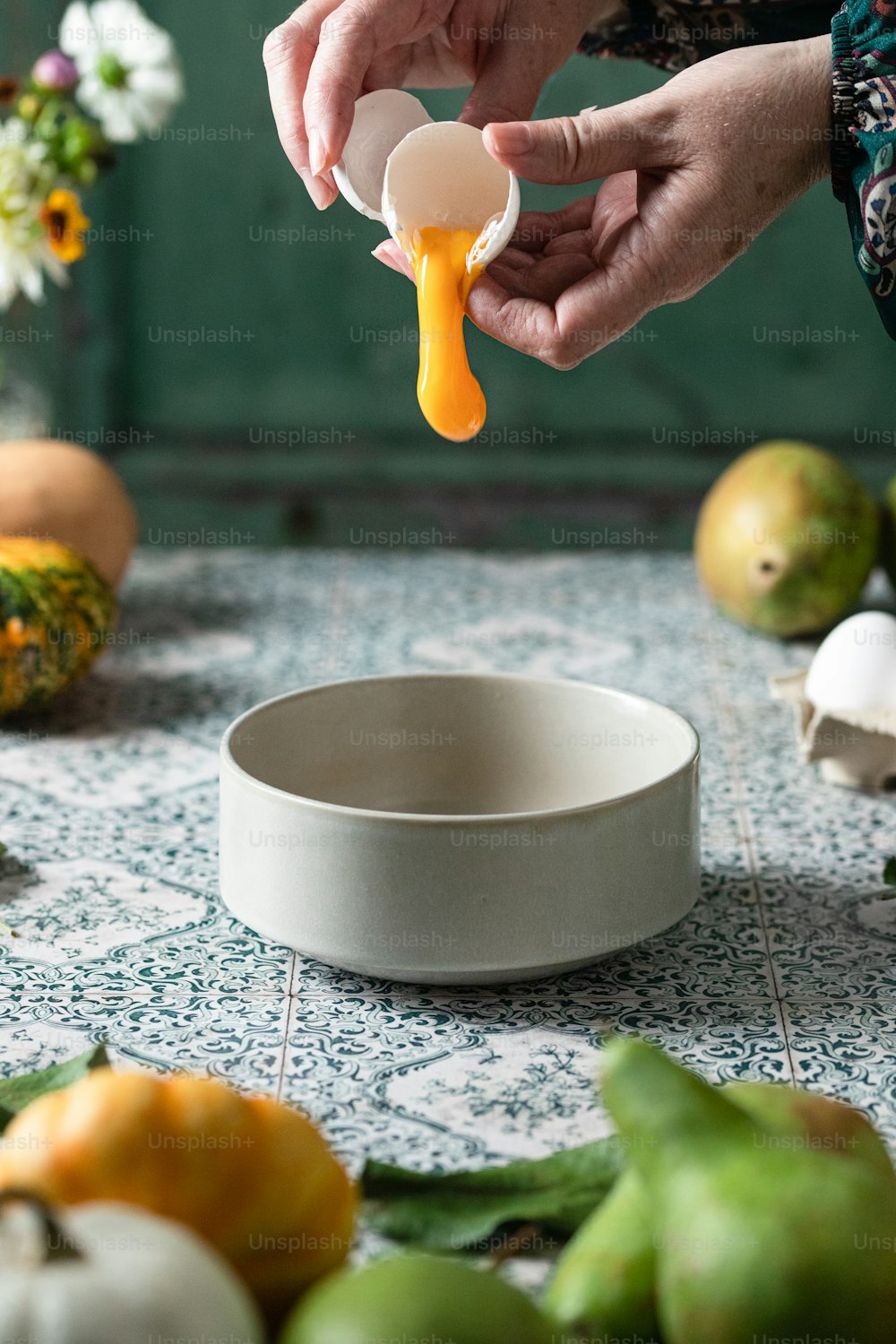 a person holding an egg over a bowl of food