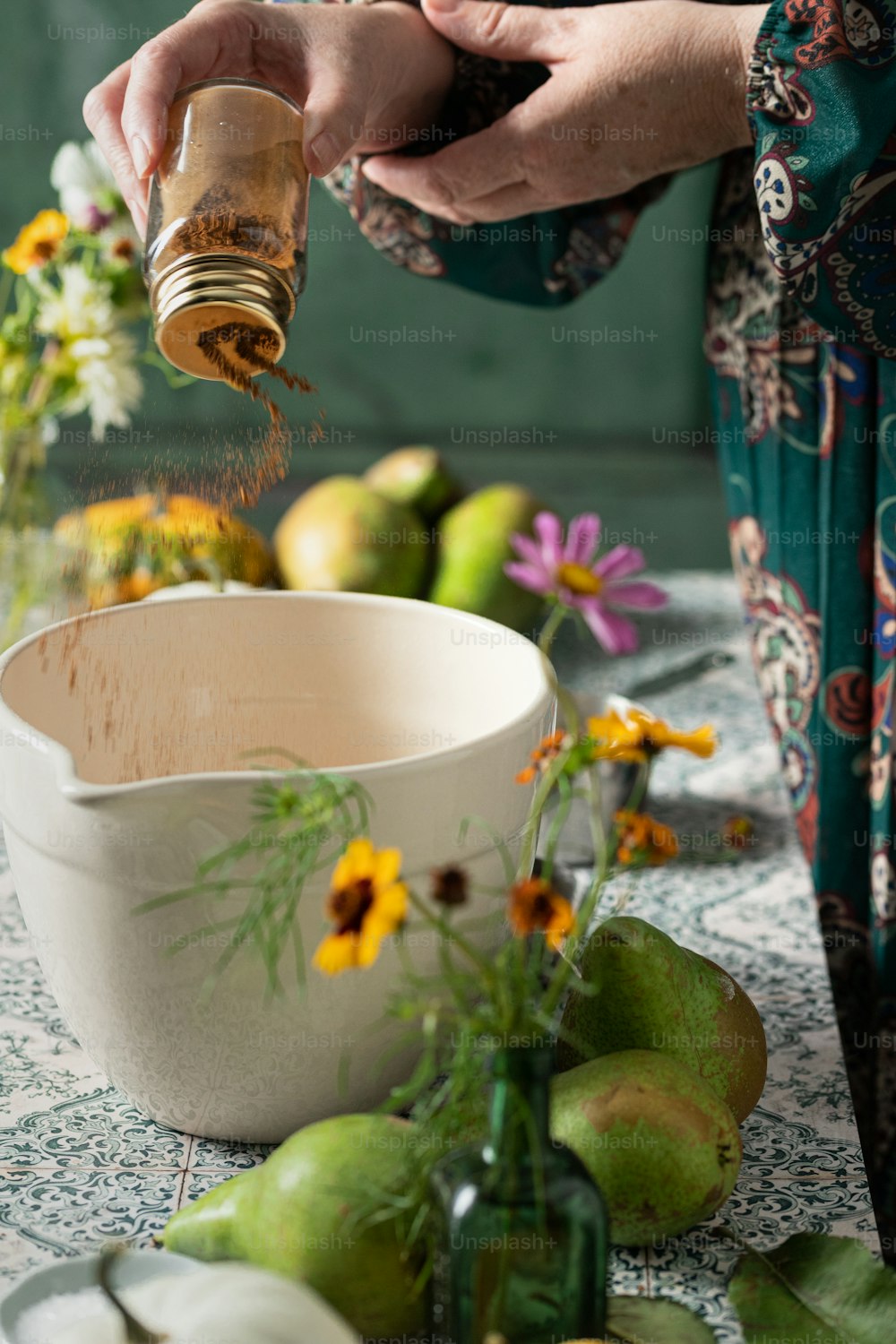 a woman is sprinkling spices into a bowl