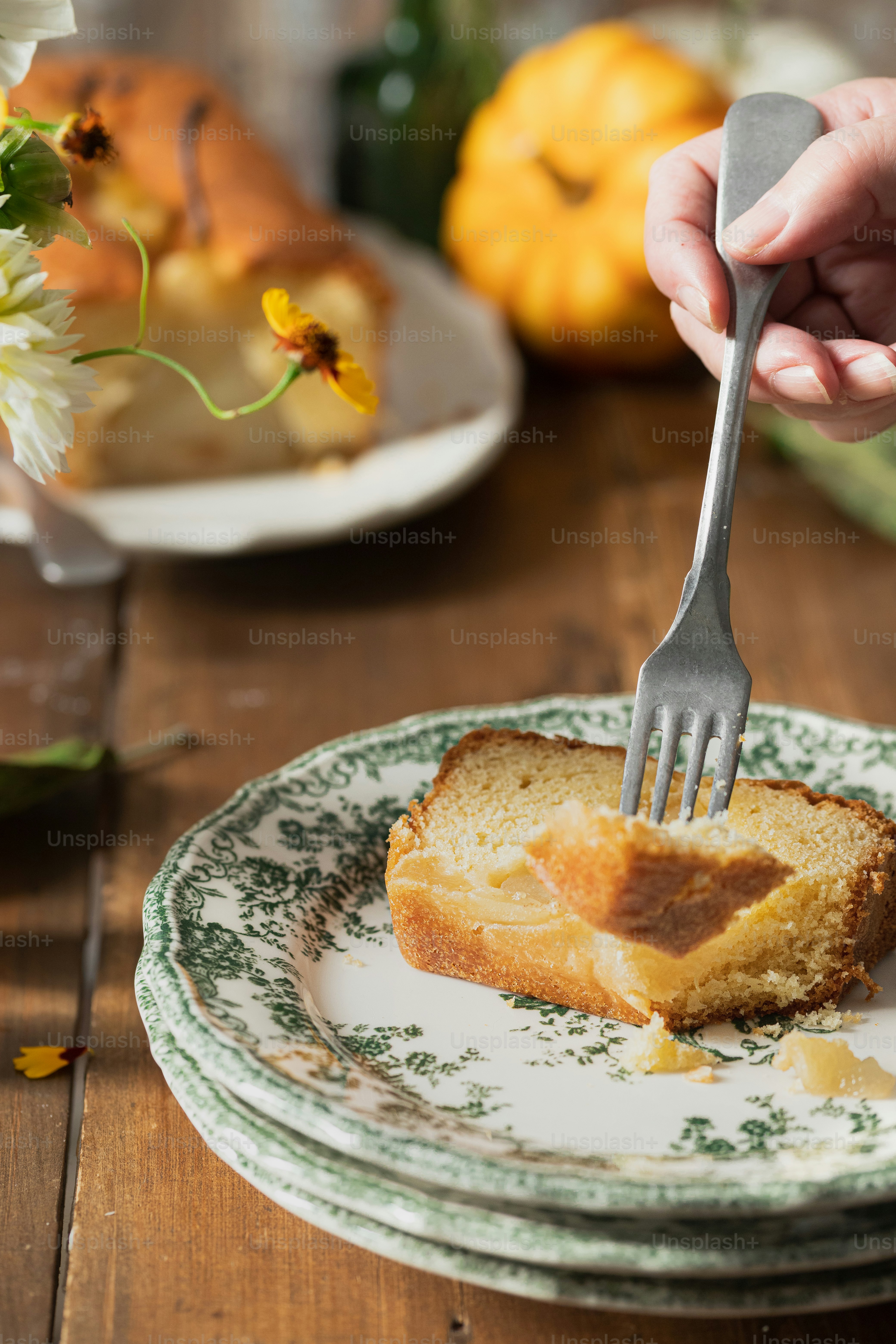 a person holding a fork over a piece of bread