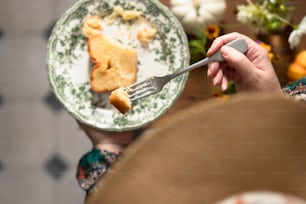 a person holding a fork and a plate with a piece of pie on it