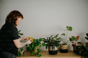 una donna in piedi davanti a un mazzo di piante