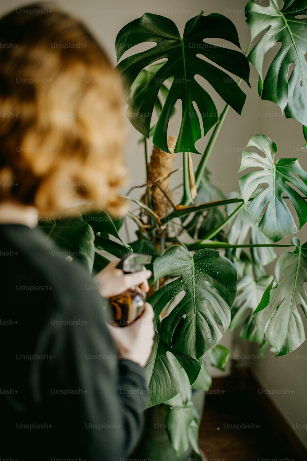 a woman standing next to a green plant