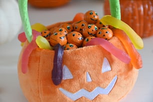 a pumpkin filled with candy sitting on top of a table