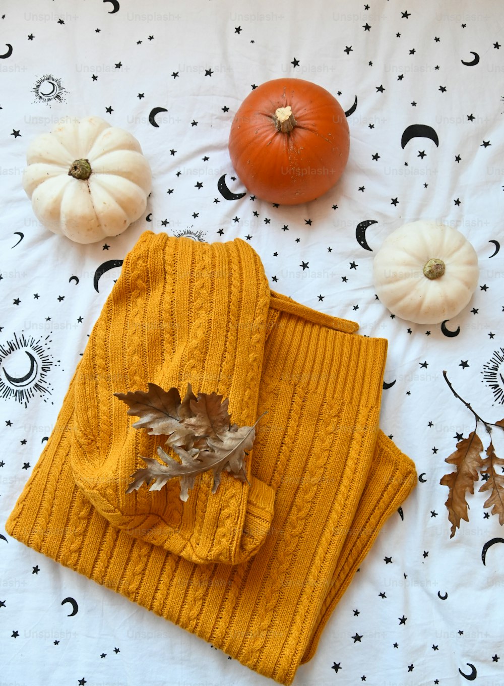 a table topped with pumpkins and a yellow sweater