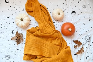 a blanket and pumpkins on a bed