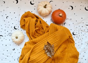 a yellow sweater and pumpkins on a table