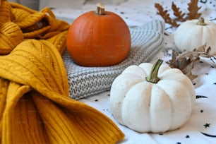 a table topped with white pumpkins and a yellow blanket