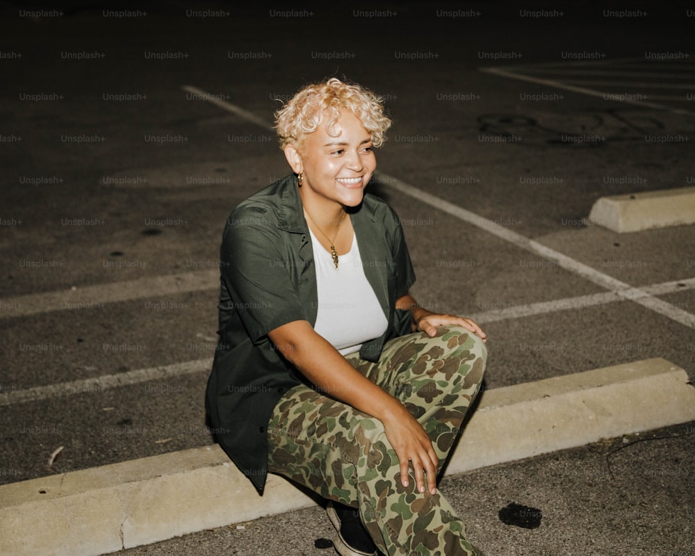 a woman sitting on the ground in a parking lot