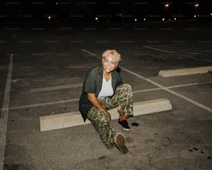 une femme assise par terre dans un parking