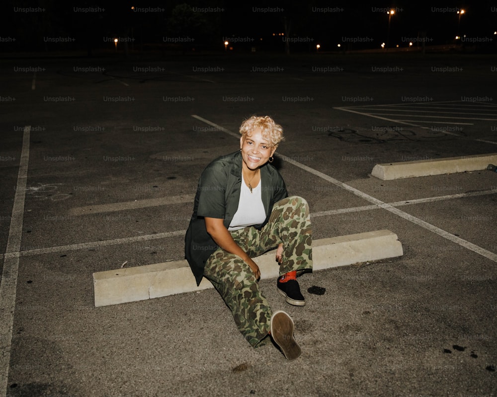 a woman sitting on the ground in a parking lot