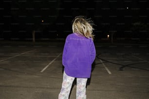 Eine Frau, die nachts auf einem Parkplatz steht