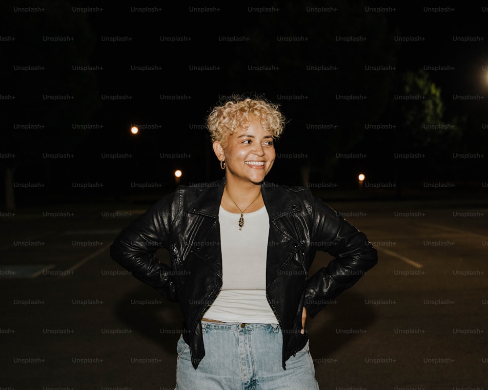 a woman standing in a parking lot at night