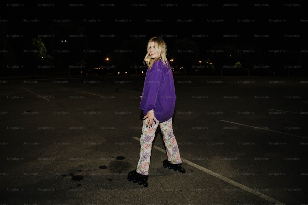 a woman walking in a parking lot at night