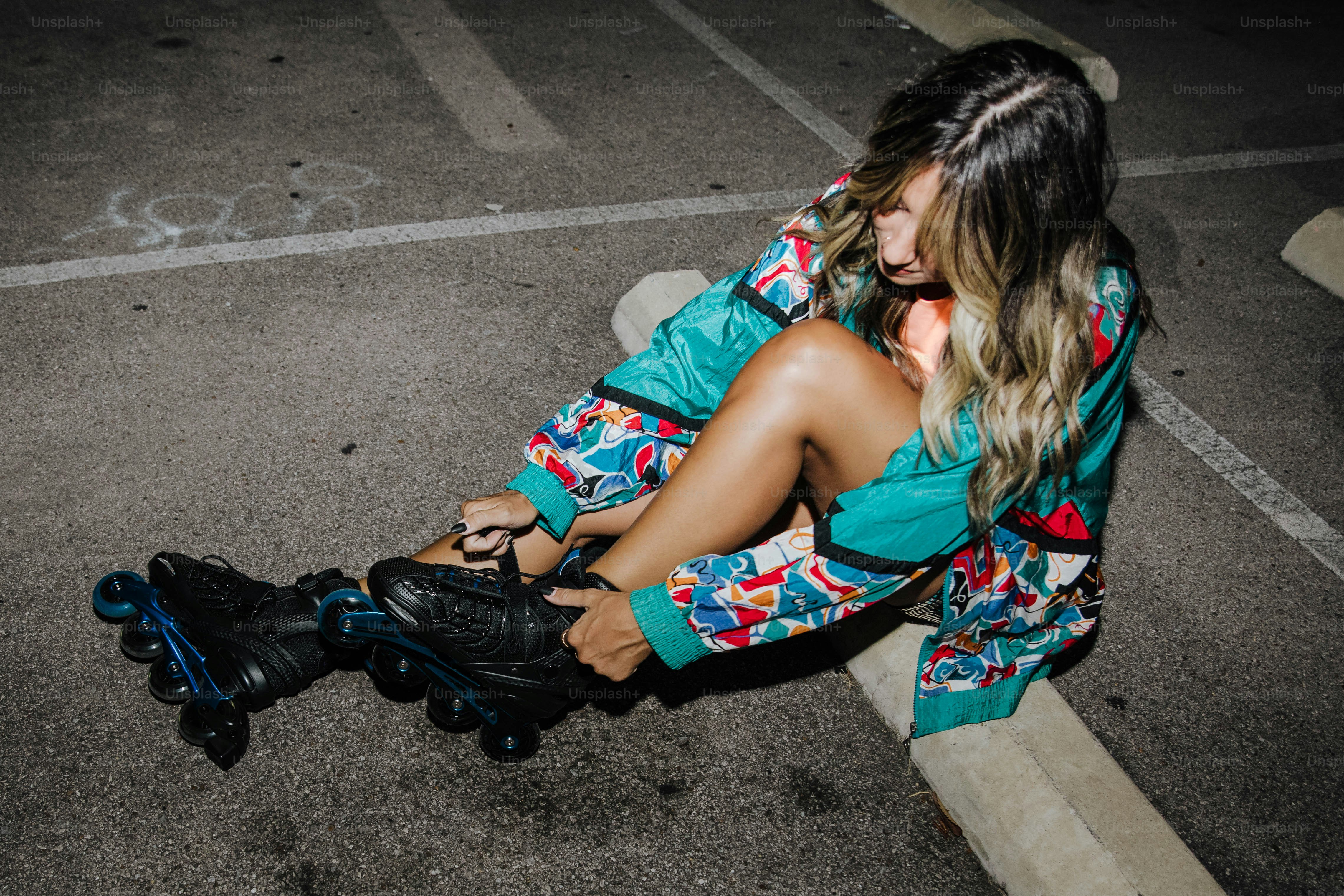 Eine Frau, die mit Rollschuhen auf dem Boden sitzt