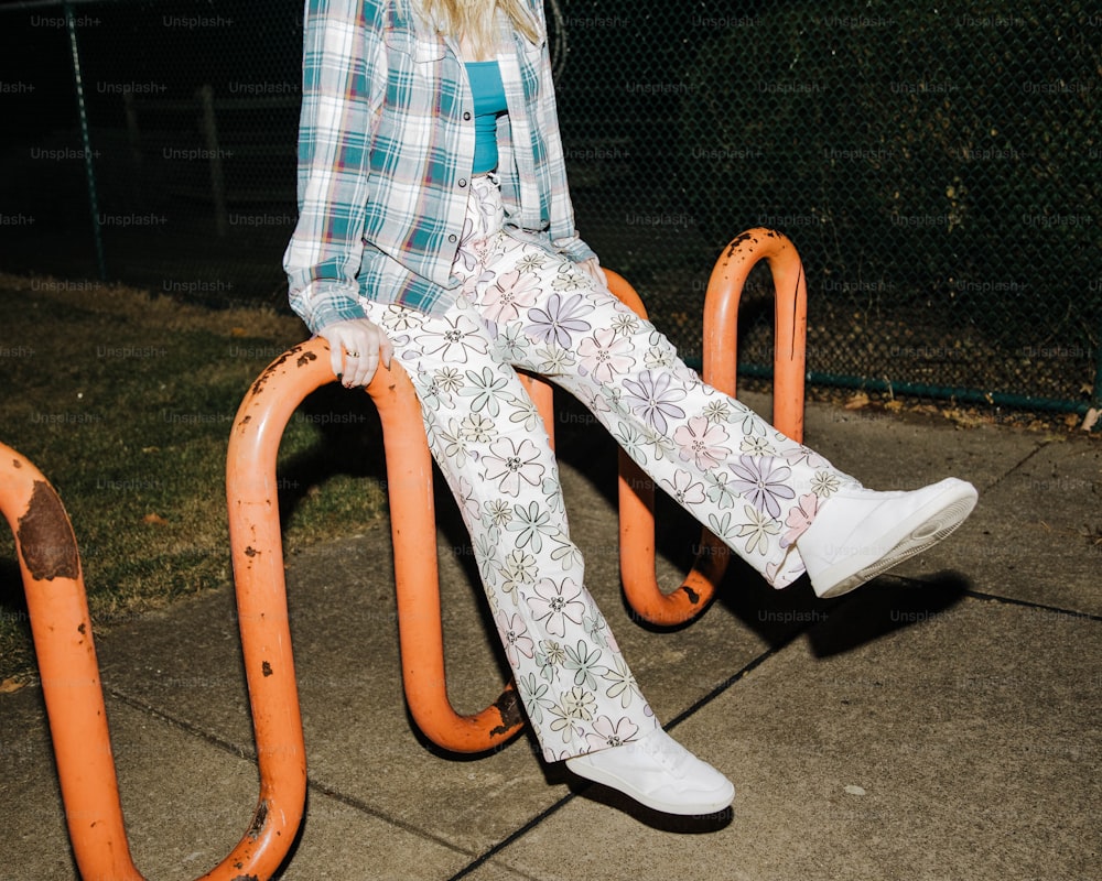 Ein junges Mädchen, das auf einer Spielplatzrutsche sitzt