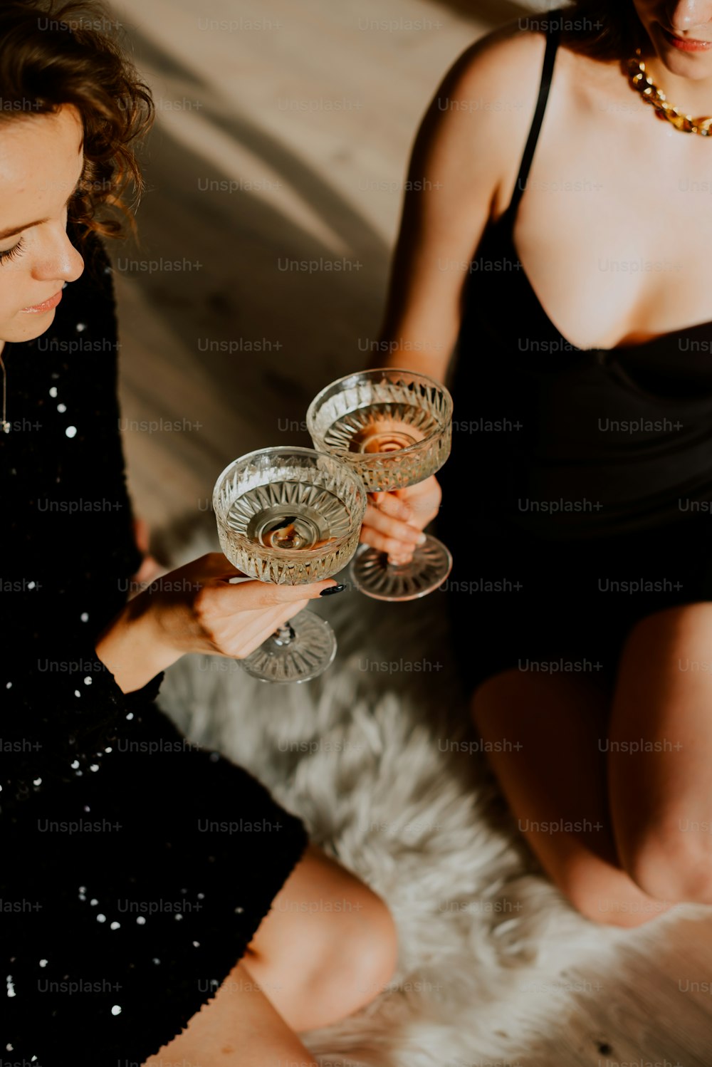 Une femme en robe noire tenant un verre de vin