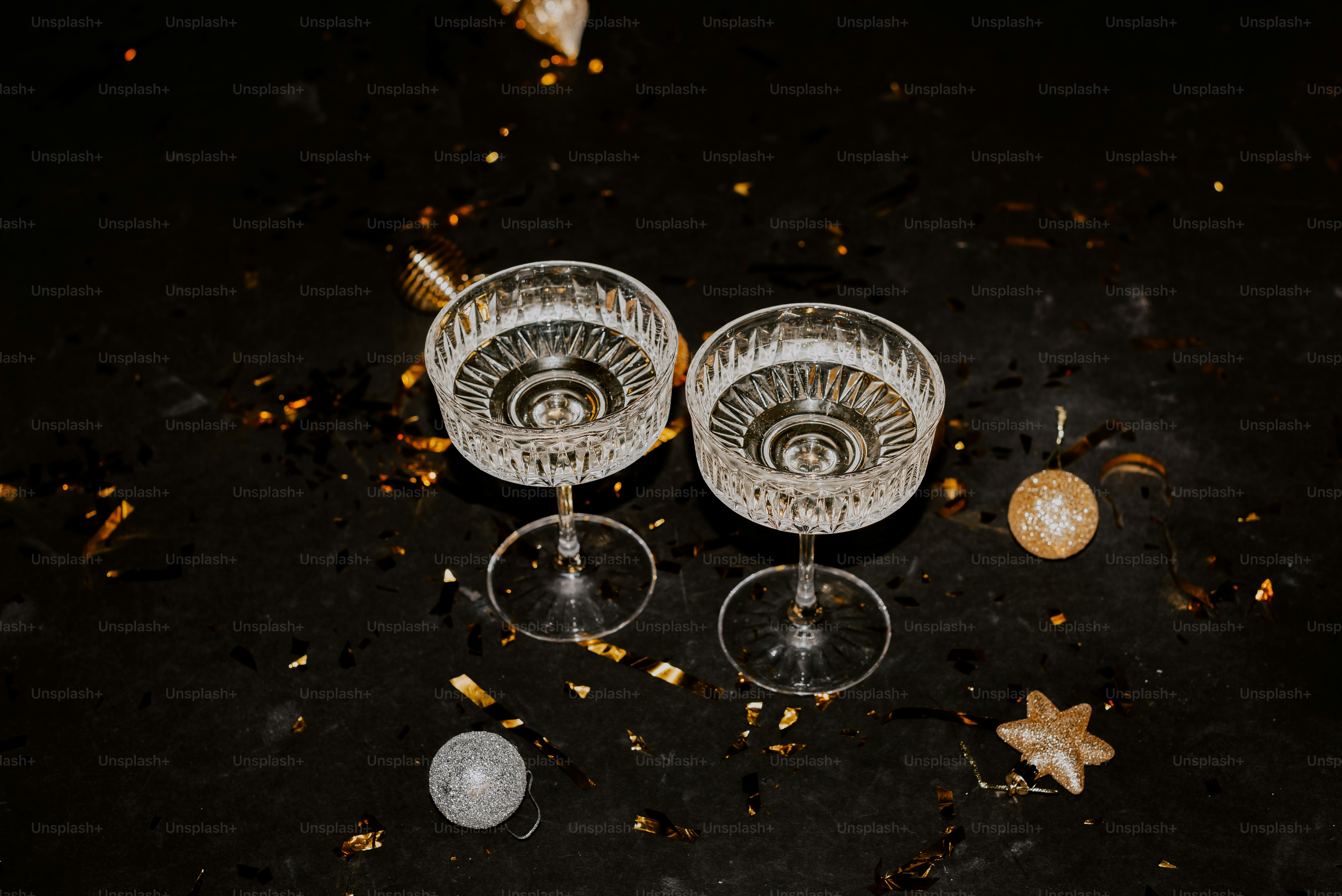 Un par de copas de vino sentadas encima de una mesa