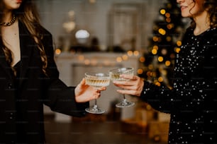 a couple of women standing next to each other holding wine glasses