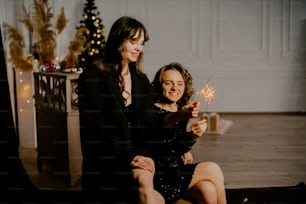 two women sitting on the floor holding sparklers