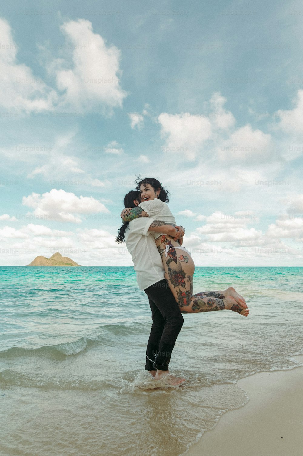한 남자와 한 여자가 해변에서 포옹한다