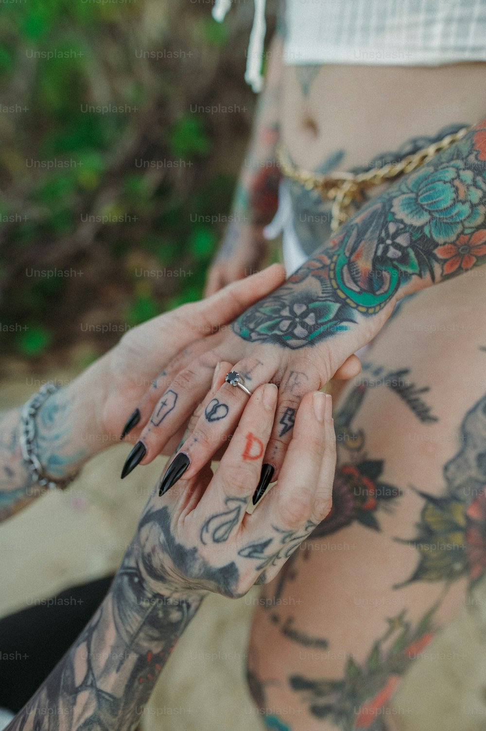 a woman with tattoos on her body holding her hand