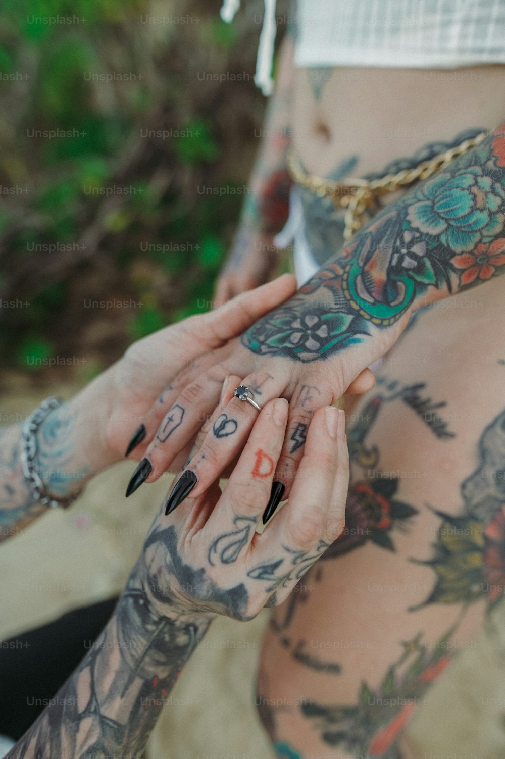 a woman with tattoos on her body holding her hand