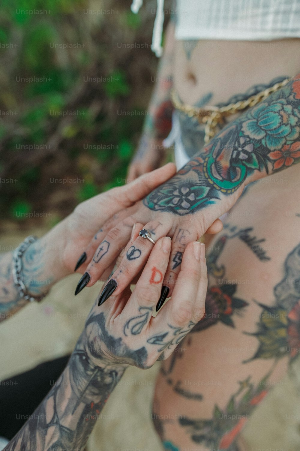 Eine Frau mit Tätowierungen auf ihrem Körper, die ihre Hand hält