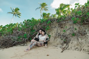 a couple of women sitting on top of a sandy beach