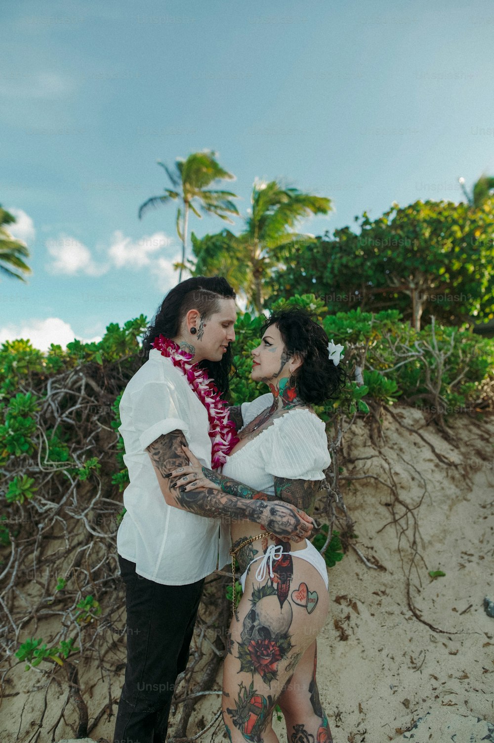 a man and a woman standing next to each other on a beach