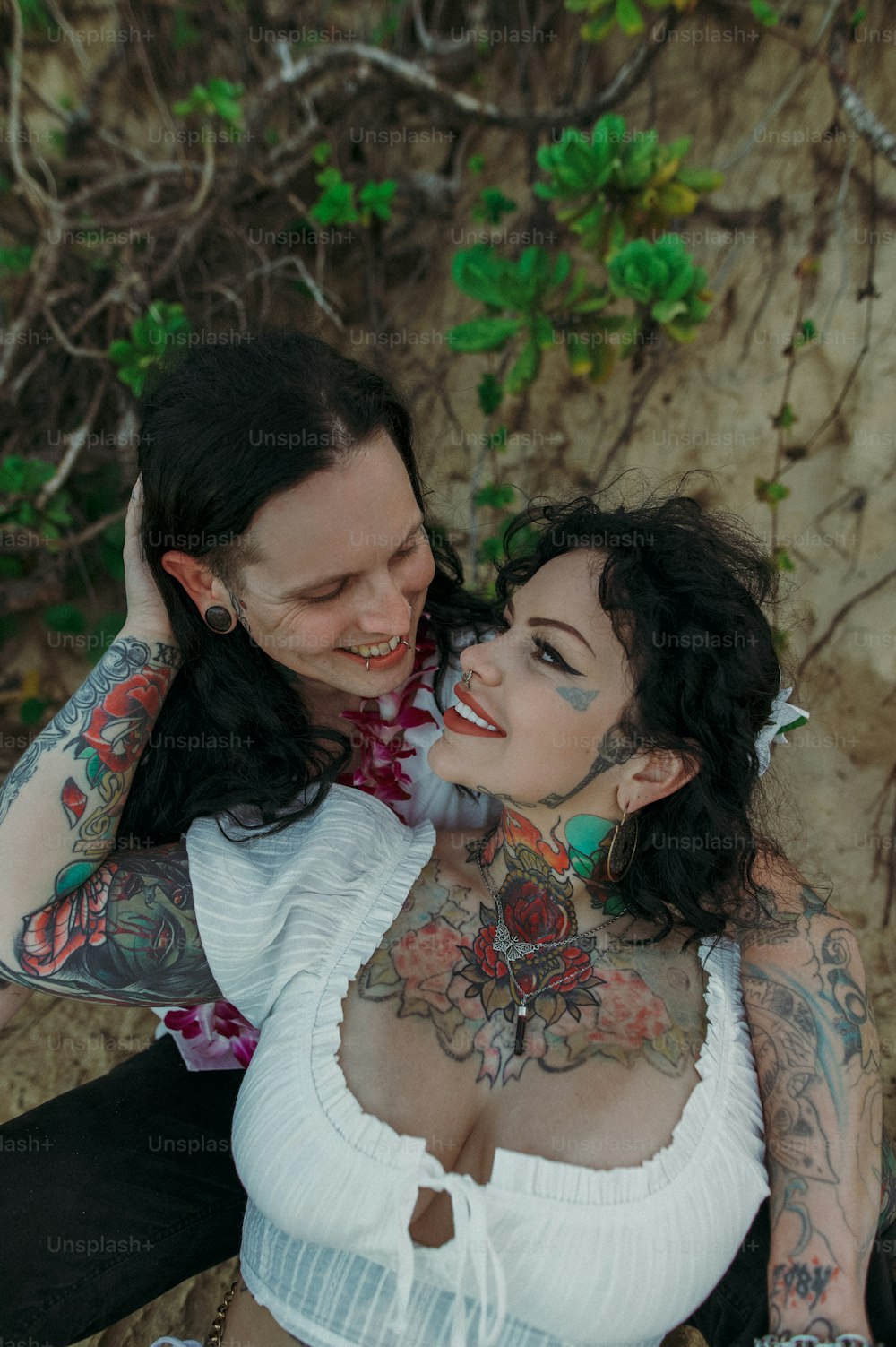 a woman with tattoos sitting next to a man