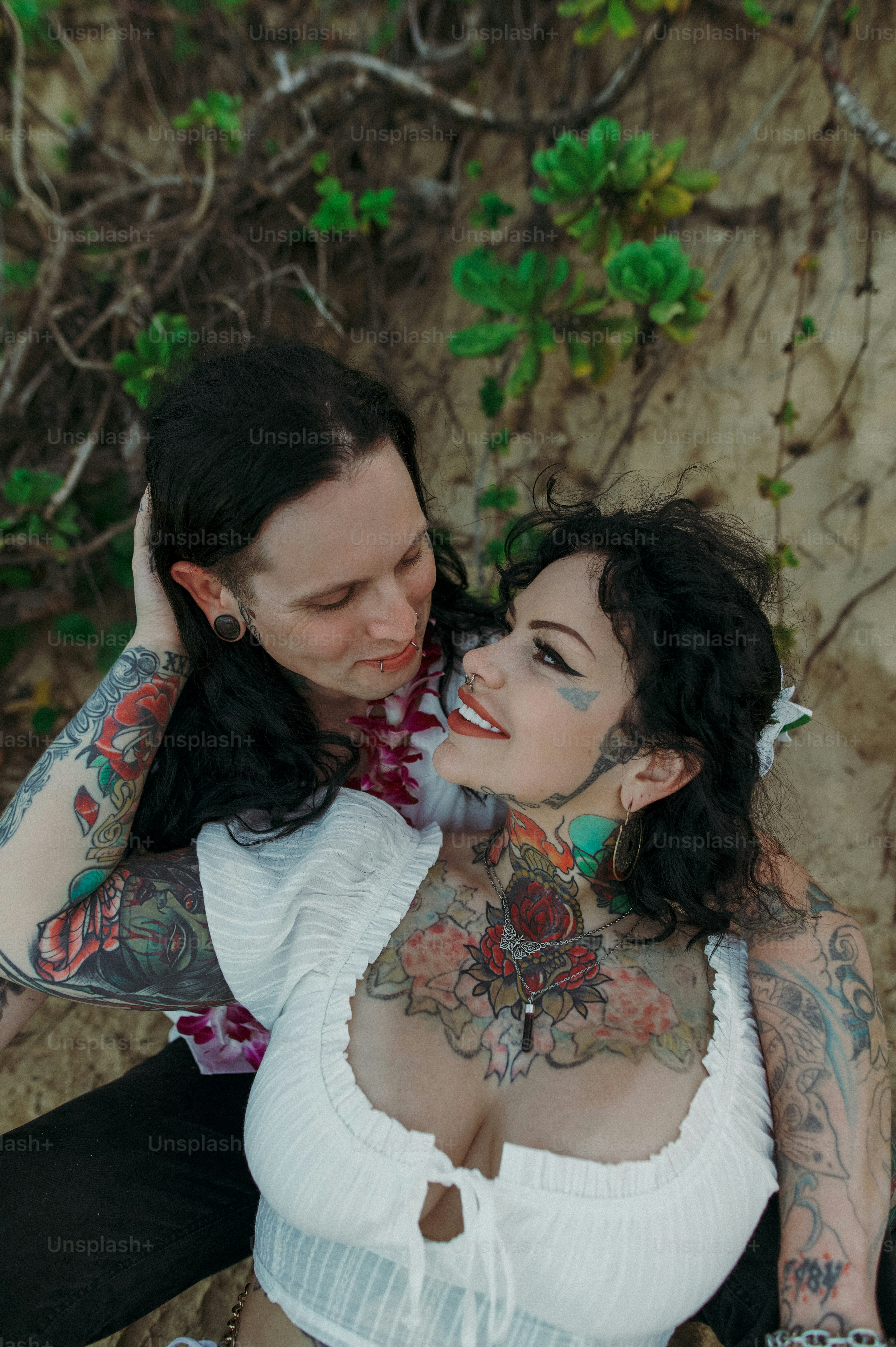 a woman with tattoos sitting next to a man