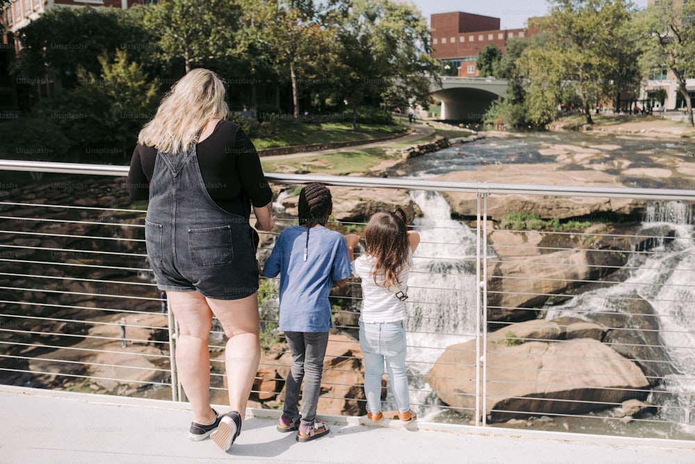 滝を見つめる女性と二人の子供