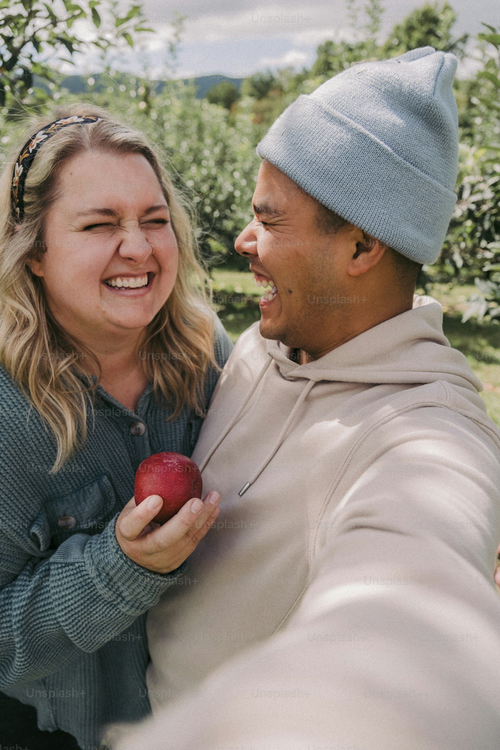 a man and a woman holding an apple together