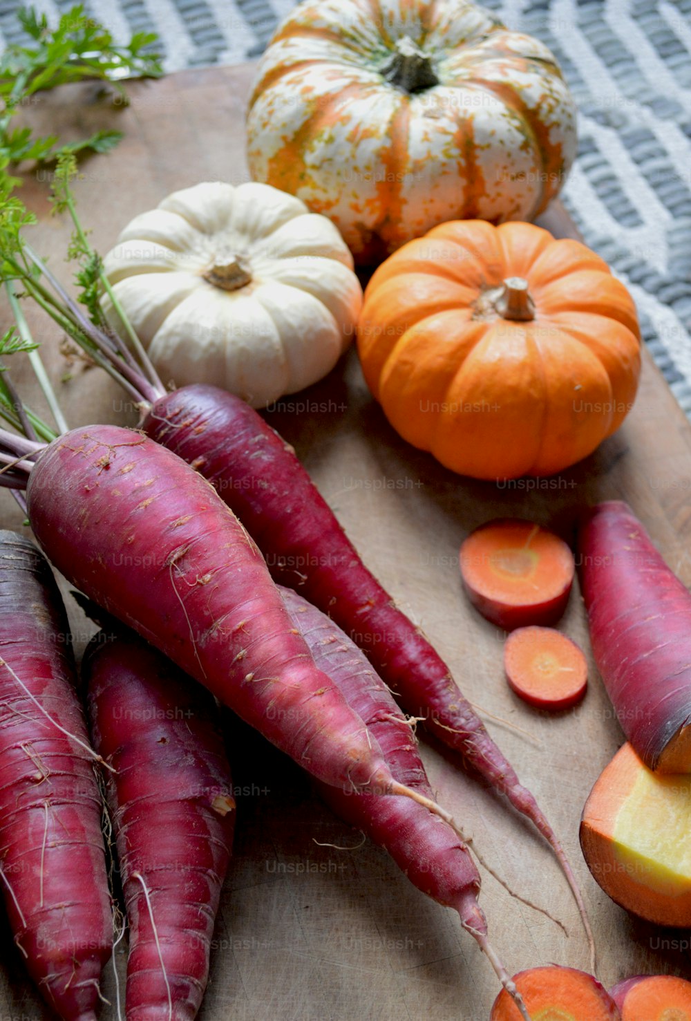 a cutting board topped with carrots and squash