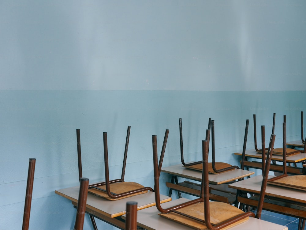 Una fila di scrivanie di legno in una stanza blu
