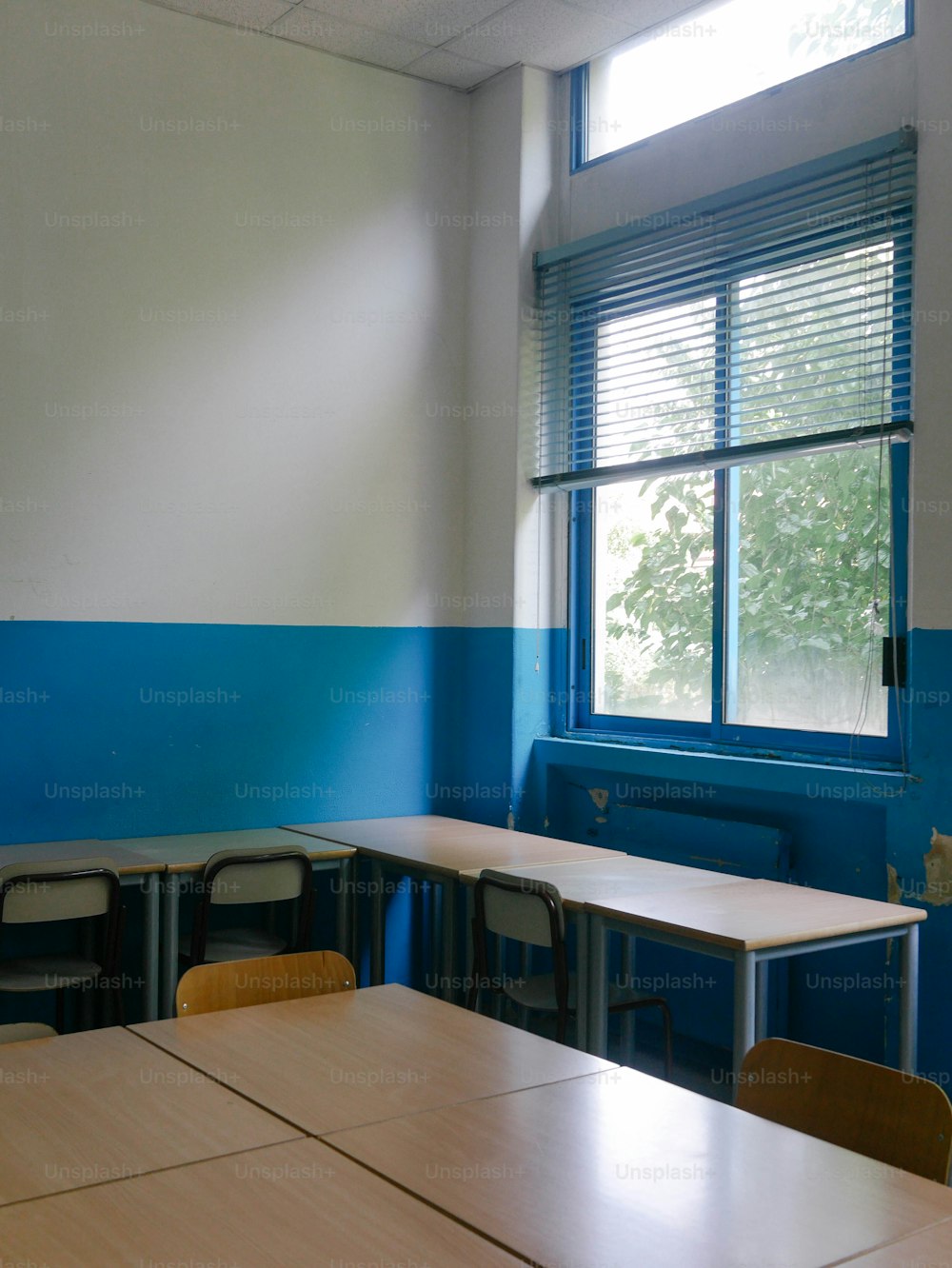 Un aula vacía con paredes azules y blancas