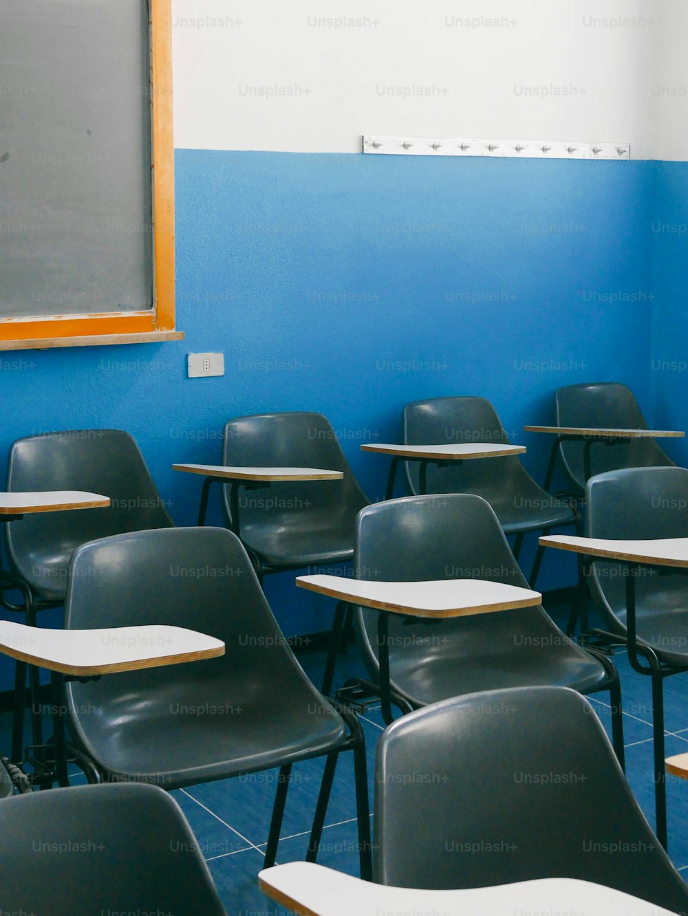 a classroom with a blue wall and a chalkboard